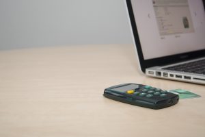 Bild som visar en bankdosa intill en laptop.